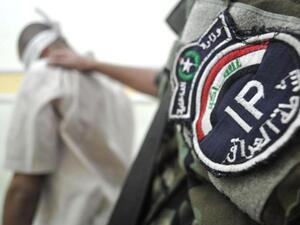 شرطي عراقي يعتقل احد المشتبهين/أ.ف.[