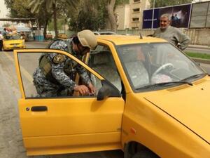 شرطي يفتش سيارة في بغداد في اطار اجراءات امنية لمنع التفجيرات/أ.ف.ب