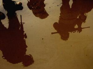 جنود اميركيون صورهم منعكسة على طريق فاضت فيه المياه في تكريت شمال العراق
