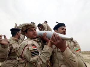 جنود عراقيون يحملون قذيفة اثناء الاشتباكات مع مسلحي الدولة الاسلامية جنوبي الموصل 
