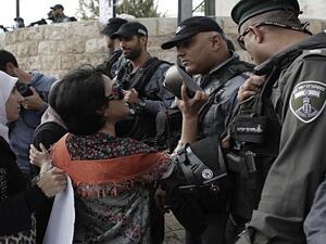 A Palestinian woman blocked from entering the al-Aqsa Mosque compound, Islam's third most holy site, holds up a Quran during clashes with Israeli Occupation Forces on Oct. 13, 2014. (AFP/Ahmad Gharabli)