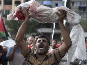 Palestinian man hold his child killed by Israeli Army fire (AFP/File Photo)	