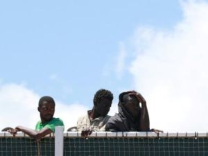 مهاجرون ينتظرون إنزالهم من سفينة دوريات للدرك الإسباني في مرفأ ساليرنو بجنوب غرب إيطاليا

