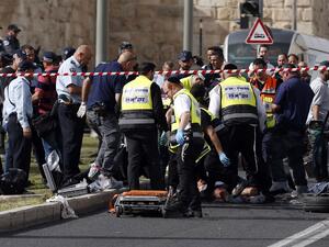Israeli emergency personnel and security forces gather at the scene of an attack outside Jerusalem's Old City's New Gate on March 9, 2016. (AFP/Ahmad Gharabli)