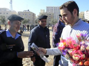 متظاهر يهدي ورودا لرجال الشرطة خلال مسيرة نظمتها المعارضة الجمعة في العاصمة الاردنية عمان/أ.ف.ب