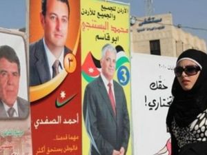 امراة تمر امام لافتات انتخابية لمرشحين في العاصمة عمان