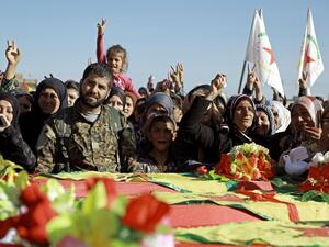 Syrian Kurds mourn next to coffins as they attend the funeral procession of four Kurdish fighters in the northeastern Syrian city of Qamishli on February 18, 2016. (AFP/Delil Souleiman)