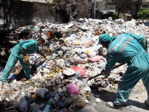 Lebanese street cleaners collect trash from Beirut a week after protesters shut down the country's largest landfill, leaving piles of trash on July 26, 2015. (AFP/Anwar Amro)
