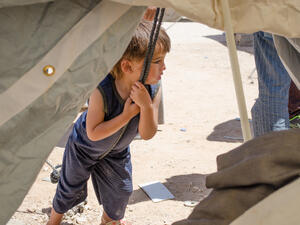A child leans on a rope supporting his new home at Zaatari refugee camp (Albawaba/J. Zach Hollo)