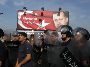 رجال امن لبنانيون يحرسون لافتة لاردوغان خلال تظاهرة مناهضة لزيارته في بيروت