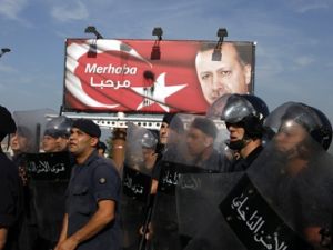 رجال امن لبنانيون يحرسون لافتة لاردوغان خلال تظاهرة مناهضة لزيارته في بيروت