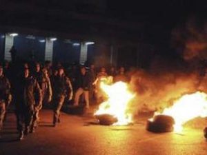 جنود لبنانيون يسيرون قرب اطارات اشعلها انصار الحريري في احد الشوارع الرئيسية