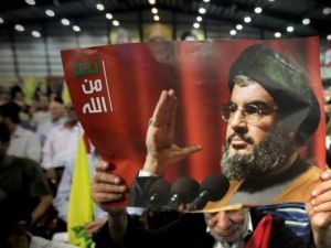 رجل يحمل صورة للامين العام لحزب الله خلال مشاركته في احتفال بمناسبة "يوم شهيد حزب الله"