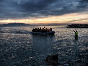 Refugees and migrants massed onto an inflatable boat reach Mytilene, northern island of Lesbos, after crossing the Aegean sea from Turkey on February 17, 2016. (AFP/Aris Messinis)