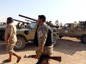 Armed fighters loyal to the Fajr Libya (Libya Dawn), an alliance of Islamist-backed militias, walk next to their vehicles on March 15, 2015 in Libya's coastal city of Sirte. (AFP/File)