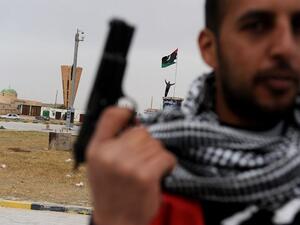A rebel fighter stands at a roundabout in the center of town in Ajdabiya, Libya on March 15, 2011. (Roberto Schmidt/ AFP)