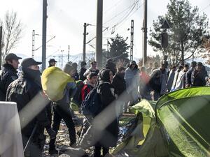 Greek policemen remove Afghan migrants from the Macedonian border to enable other migrants from Syria and Iraq to cross near Gevgelija on February 23, 2016. (AFP/Robert Atanasovski)