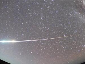 AUSTRALIA, Woomera : A handout photo taken with a fish-eye lens on June 13, 2010, and released on June 14 shows the capsule carried by the Hayabusa spacecraft burning up over South Australia on re-entry, leaving the heat-resistant pod to parachute back to land within the Woomera military zone.  