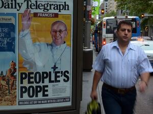A man walks past an advertising billboard displaying the front page of Sydney's tabloid newspaper the Daily Telegraph with picture of Pope Francis, Argentina's Jorge Mario Bergoglio. (AFP PHOTO/ Saeed KHAN)