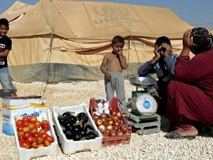 A Syrian refugee woman sells vegetables at the Zaatari refugee camp, (AFP PHOTO/KHALIL MAZRAAWI)