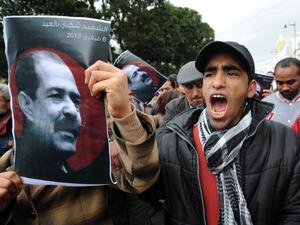A Tunisian protester holds a placard featuring killed opposition leader Chokri Belaid during a demonstration on Saturday. (AFP PHOTO / FETHI BELAID)