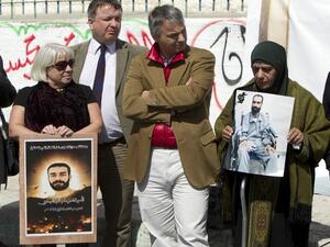 Layla Issawi (R) holds a picture of her son Samer Issawi, a Palestinian held in Israeli jail and on hunger strike for more than 200 days. (AFP PHOTO/AHMAD GHARABLI)