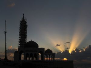 A mosque under construction is silhouetted as the sun sets along the seafront in Gaza City. (AFP Photo / MAHMUD HAMS)