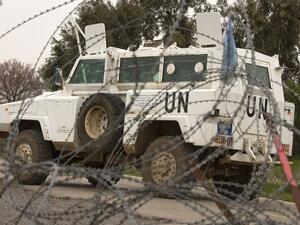 A UN vehicle is seen driving behind barbwire as UN peacekeepers leave a post, in the demilitarised United Nations Disengagement Observer Force (UNDOF) zone, in the Golan Heights. (AFP PHOTO/JACK GUEZ)