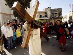 A Christian man holds a large wooden cross as Lebanese Christians reenact the crucifixion of Jesus Christ during the Good Friday procession in the southern village of Qraiyeh. (AFP PHOTO/MAHMOUD ZAYAT)