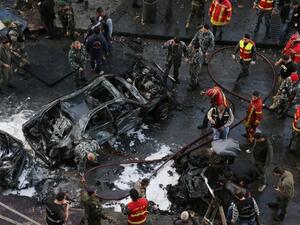 Lebanese security forces and firefighters at the scene of a huge car bomb explosion that rocked central Beirut on December 27, 2013. [AFP]