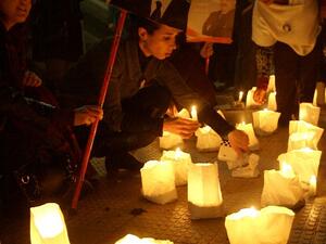 Lebanese supporters of the Mostaqbal Movement bloc light candles during a vigil as others holds pictures of former Lebanese premier Rafiq Harir and his son former prime minister Saad Hariri in the southern Lebanese city of Sidon. [AFP]