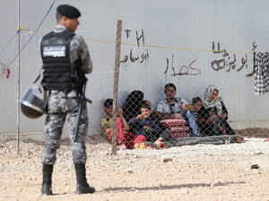 Jordanin Police keep guard as Syrian refugees look on at the King Abdullah Refugee Camp for Syrian refugees 2 kilometers from the Syrian border  (Photo by Chris Jackson/Getty Images) 