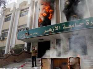A man stands outside a faculty building at Cairo's Al-Azhar University after student supporters of the Muslim Brotherhood stormed it on December 28, 2013. [AFP]