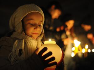 A young girl holds a candle outside Saint Gregory the Illuminator church in the Armenian capital of Yerevan during an Armenian Orthodox Christmas Eve church service on January 5, 2014. (AFP)
