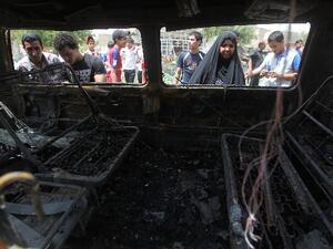 By-standers look at the wreck of a bomb used in a sectarian suicide attack in Baghdad. AFP Photo