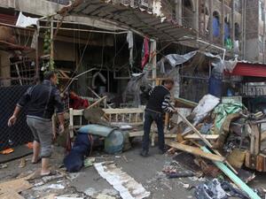 Iraqi men clean the rubble at the site of a blast that took place the previous day outside a cafe in Baghdad's Bayaa neighborhood on November 21, 2013. One day after attacks killed 59 people across Iraq, a car bomb exploded in a busy market northeast of the capital. (AFP)