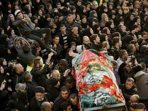 People carry one of the two bodies during the funeral of Malak Zahwa and her step-mother Iman Hijazi, who both died in a car bomb that targeted a Beirut's suburb the day before on January 3, 2014. The death toll of the blast has now risen to six. (AFP)