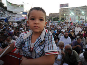  An Egyptian boy poses for the camera as supporters of the deposed president Mohamed Morsi attend the sit-in at Rabaa al-Adawiya square in Cairo (AFP/FAYEZ NURELDINE)