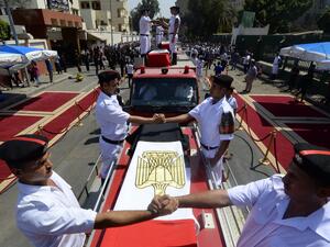 Egyptian policemen stand on vehicles carrying the coffins of their comrades during their funeral in Cairo (AFP/KHALED DESOUKI)
