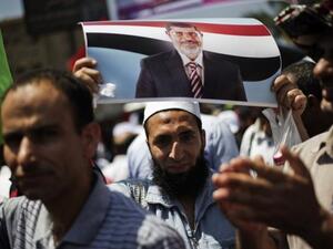 A protester is seen with a picture of President Mohamed Morsi, at the Rabaa al-Adawiya mosque in Cairo, on June 28, 2013 (AFP/File)