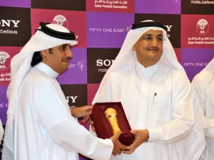 Mr. Khaled Al-Kuwari handing a miniature Emir's Cup to Mr. Bader as a token of QFA's appreciation
