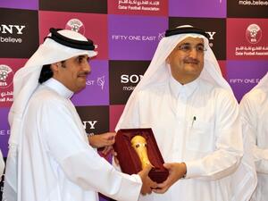 Mr. Khaled Al-Kuwari handing a miniature Emir's Cup to Mr. Bader as a token of QFA's appreciation