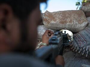  A Syrian rebel fighter points his rifle through a hole in sandbags as he holds a position in a trench, 100m away from the regime-controlled military base of Wadi Deif in Idlib province. AFP photo