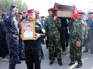 Military officers carry the coffin of a comrade during his funeral in the city of Nasiriyah, on December 31, 2013, after he was killed in fighting in the western Anbar province. (AFP)
