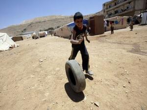 A young Syrian boy plays with a tyre at the Arsal refugee camp on June 14, 2013 in Lebanon (AFP/File)
