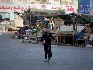 A Lebanese man runs in the street at the entrance of Tripoli's Bab al-Tabbaneh Sunni area during clashes with the Alawite, pro-Syrian President Bashar al-Assad, Jabal Mohsen neighbourhood in the northern Lebanese city on December 2, 2013. The clashes have wounded at least 61 people, among them 12 members of the Lebanese army, which is deployed in the city and is responding to the sources of fire, the security source said. (AFP)
