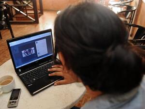 A woman looks at a Facebook page in Agadir published in support of the three Moroccan teenagers arrested for posting Facebook photos of two of them kissing outside their school in the northern town of Nador last week. (AFP)