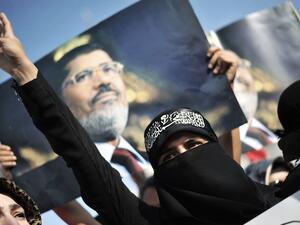 A woman protestor chants slogans in front of a poster of Egypt's ousted president Mohamed Morsi during a demonstration condemning the recent deadly military crackdown on pro-Morsi protesters in Cairo on August 17, 2013 in Istanbul. (AFP)