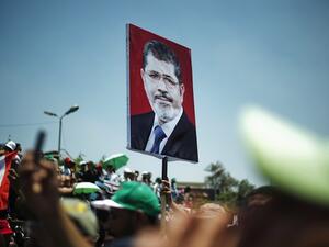 Egyptian Islamist groups led by the ruling Muslim Brotherhood shout slogans during a demonstration to mark the upcoming one year anniversary since President Mohamed Morsi (portrait) was elected, on June 21, 2013 in Cairo. (AFP)