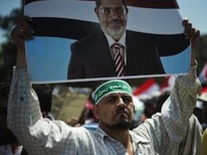 Egyptian Islamist groups led by the ruling Muslim Brotherhood take part in a demonstration to mark the upcoming one year anniversary since President Mohamed Morsi (portrait) was elected, on June 21 in Cairo. (AFP)